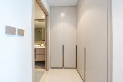 a walk in closet with white walls and a glass door at The Skyline Burj Retreat in Dubai
