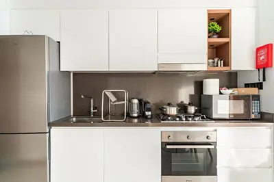 a kitchen with white cabinets and a stove top oven at Panoramic Marina 1BR City Skyline Views with Balcony, Pool & Gym Access in Dubai