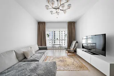 a living room with a couch and a flat screen tv at High-Floor 1BR at Elite Residence, Dubai Marina in Dubai