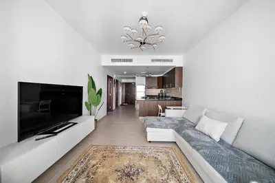 a living room with a couch and a television at High-Floor 1BR at Elite Residence, Dubai Marina in Dubai