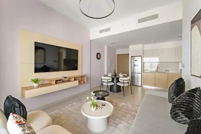 a living room with a couch and a tv at Elegant 1BR Near Burj Khalifa and Dubai Mall with Pool, Balcony, & Gym in Dubai