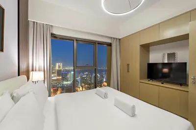 a hotel room with a large bed and a large window at Elegant 1BR Near Burj Khalifa and Dubai Mall with Pool, Balcony, & Gym in Dubai