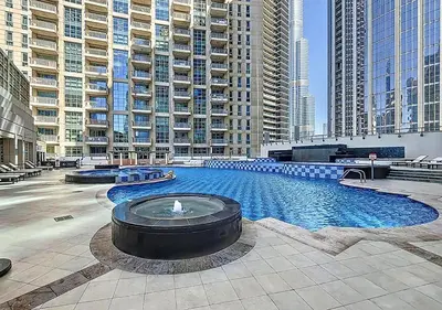 a large swimming pool in a city with tall buildings at Stunning 1 BR Apartment Walk to Burj Khalifa & Dubai mall in Dubai