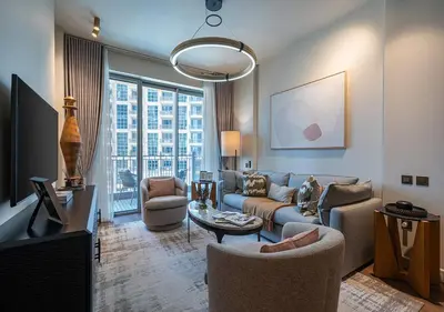 a living room with a couch and a tv at Stunning 1 BR Apartment Walk to Burj Khalifa & Dubai mall in Dubai