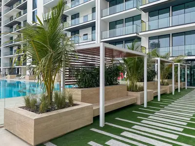 a building with palm trees and a swimming pool at DAYF-AMB Brand New Cozy 1 Bed up to 4 Guests in Dubai