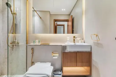 a bathroom with a sink and a toilet and a mirror at DAYF-AMB Brand New Cozy 1 Bed up to 4 Guests in Dubai