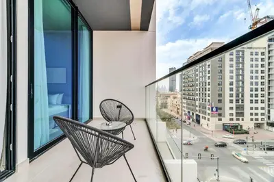 a balcony with two chairs and a view of a city at DAYF-AMB Brand New Cozy 1 Bed up to 4 Guests in Dubai