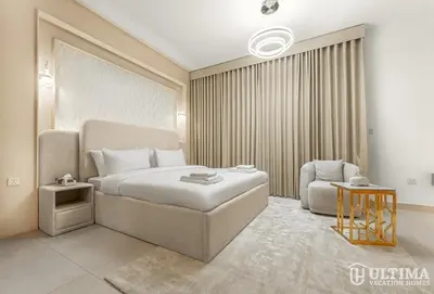 a hotel room with a bed and a chair at Lovely Studio in JVC with Summer Offer in Dubai