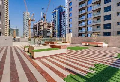 a group of benches in a city with tall buildings at Lovely Studio in JVC with Summer Offer in Dubai