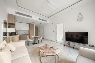 a living room with a couch and a tv and a table at Stylish 1BR in Dubai Hills - Pool, Gym & Near Dubai Hills Mall in Dubai