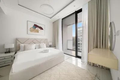 a white bedroom with a large bed and a window at Stylish 1BR in Dubai Hills - Pool, Gym & Near Dubai Hills Mall in Dubai