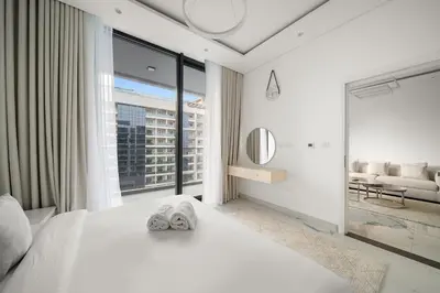 a bedroom with a white bed and a large window at Stylish 1BR in Dubai Hills - Pool, Gym & Near Dubai Hills Mall in Dubai