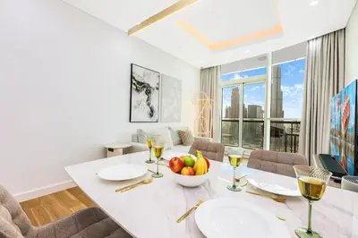 a dining room with a table with a bowl of fruit at Spacious 2BR with Balcony, Stunning Burj Views & Steps from Bay Avenue Park in Dubai