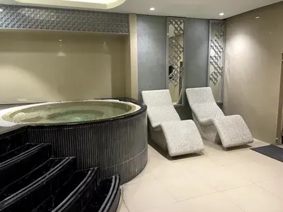 a bathroom with a hot tub and two chairs at Spacious 2BR with Balcony, Stunning Burj Views & Steps from Bay Avenue Park in Dubai