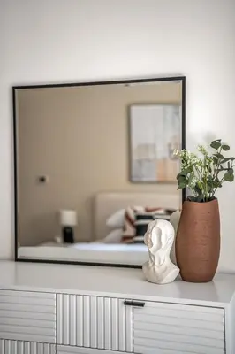 a dresser with a mirror and a vase with a plant at GuestReady - Delightful haven near Burj Khalifa in Dubai