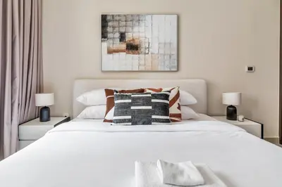 a bedroom with a large white bed with two lamps at GuestReady - Delightful haven near Burj Khalifa in Dubai