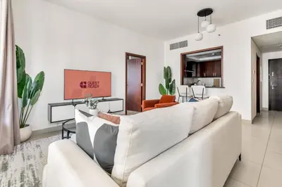 a living room with a white couch and chairs at GuestReady - Delightful haven near Burj Khalifa in Dubai