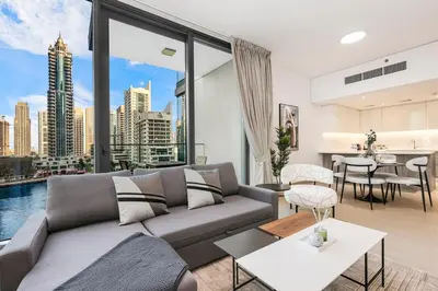 a living room with a couch and a large window at Stylish Dubai Marina 2BR with Balcony, Pool, Gym Walk to Marina Walk & JBR in Dubai