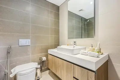 a bathroom with a sink and a toilet and a mirror at Stylish Dubai Marina 2BR with Balcony, Pool, Gym Walk to Marina Walk & JBR in Dubai