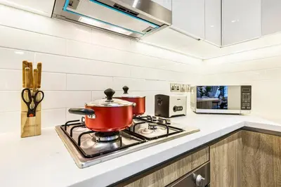 a red pot on a stove in a kitchen at Stylish Dubai Marina 2BR with Balcony, Pool, Gym Walk to Marina Walk & JBR in Dubai