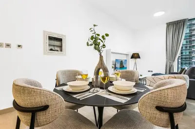 a dining room with a black table and chairs at Stylish Dubai Marina 2BR with Balcony, Pool, Gym Walk to Marina Walk & JBR in Dubai