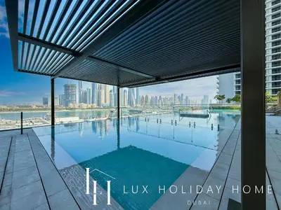 a swimming pool with a view of the city at LUX The Palace Beach Suite in Dubai