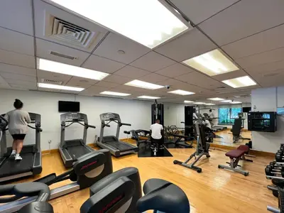 a gym with people exercising on tread machines at 29 Boulevard Tower 1 Apartment by GLOBALSTAY in Dubai