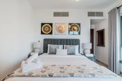 a bedroom with a large bed and some pictures on the wall at 29 Boulevard Tower 1 Apartment by GLOBALSTAY in Dubai