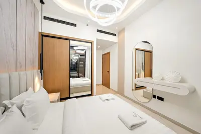 a bedroom with a large white bed and a mirror at Bright 1BR Retreat with Pool Access Near The Palm & Dubai Marina Hotspots in Dubai