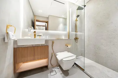 a bathroom with a toilet and a sink and a shower at Bright 1BR Retreat with Pool Access Near The Palm & Dubai Marina Hotspots in Dubai