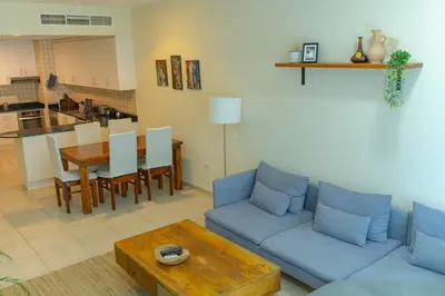 a living room with a blue couch and a table at Urban 1BHK Apartment with Sea View in Dubai