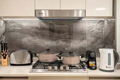 a kitchen with two pots on a stove at Luxury 1BR apt with Burj Khalifa, Canal View Pool Gym Near Dubai Mall in Dubai