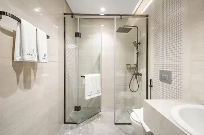 a bathroom with a shower and a toilet and a sink at Luxury 1BR apt with Burj Khalifa, Canal View Pool Gym Near Dubai Mall in Dubai