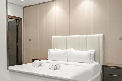 a bedroom with a white bed with towels on it at Luxury 1BR apt with Burj Khalifa, Canal View Pool Gym Near Dubai Mall in Dubai