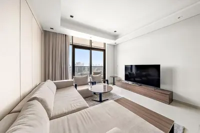 a living room with a large couch and a tv at Luxury 1BR apt with Burj Khalifa, Canal View Pool Gym Near Dubai Mall in Dubai