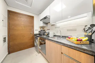 a kitchen with a sink and a bowl of fruit on the counter at FIRST CLASS Studio Classy Comfort in Dubai