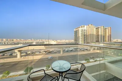 a balcony with a table and chairs and a view of a city at FIRST CLASS Studio Classy Comfort in Dubai