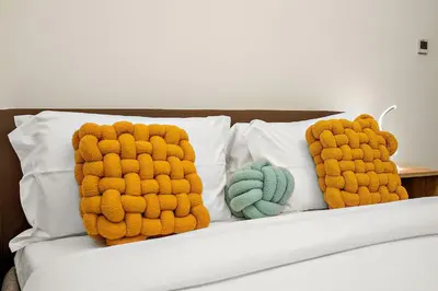 two knitted pillows on a bed with at FIRST CLASS Studio Classy Comfort in Dubai