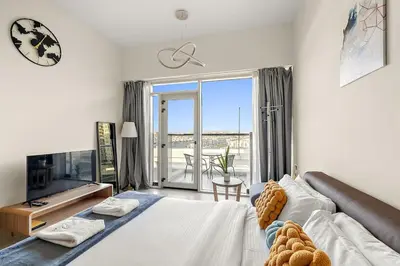 a living room with a large bed and a tv at FIRST CLASS Studio Classy Comfort in Dubai