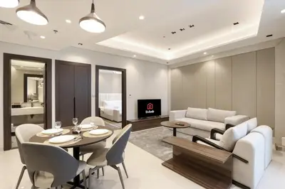 a living room with a table and chairs and a couch at High-Floor 1BR with Burj Khalifa View Prime Location in Dubai