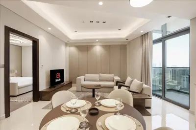 a living room with a table and chairs and a couch at High-Floor 1BR with Burj Khalifa View Prime Location in Dubai
