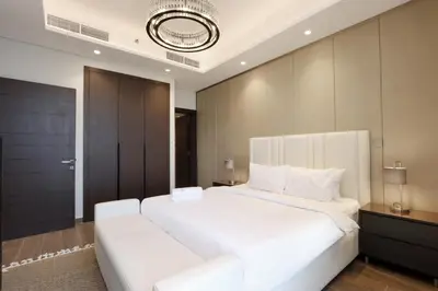 a bedroom with a large white bed and a couch at High-Floor 1BR with Burj Khalifa View Prime Location in Dubai