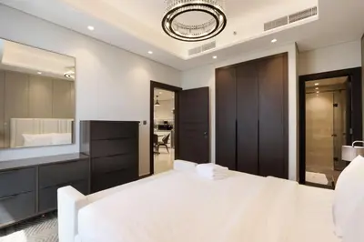 a bedroom with a white bed and a mirror at High-Floor 1BR with Burj Khalifa View Prime Location in Dubai