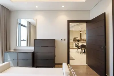 a bedroom with a door leading to a dining room at High-Floor 1BR with Burj Khalifa View Prime Location in Dubai