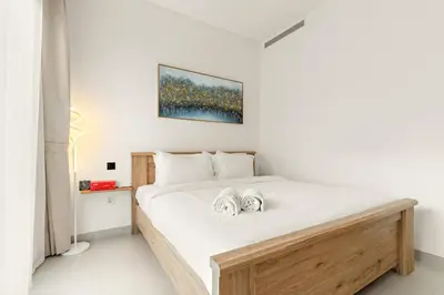 a bedroom with a bed with two towels on it at Elegant 1BR Stay in Sobha Creek Luxury Apartment Near Dubai Canal in Dubai