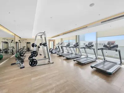 a gym with a row of treadmills and machines at Elegant 1BR Stay in Sobha Creek Luxury Apartment Near Dubai Canal in Dubai