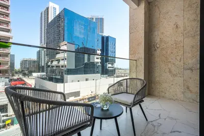 a balcony with two chairs and a table at Heaven Crest Vacation Homes - One Bedroom City View Balcony in Azizi Riviera in Dubai