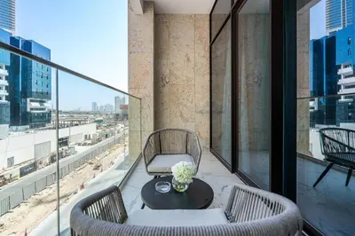 a balcony with a table and chairs and a view of a city at Heaven Crest Vacation Homes - One Bedroom City View Balcony in Azizi Riviera in Dubai
