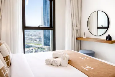 a bedroom with a bed with a mirror and a window at Emaar Burj Crown - 1BR Sea View across from Burj Khalifa, walk to Dubai Mall in Dubai