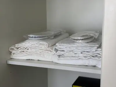 a pile of towels sitting on a shelf at Emaar Burj Crown - 1BR Sea View across from Burj Khalifa, walk to Dubai Mall in Dubai